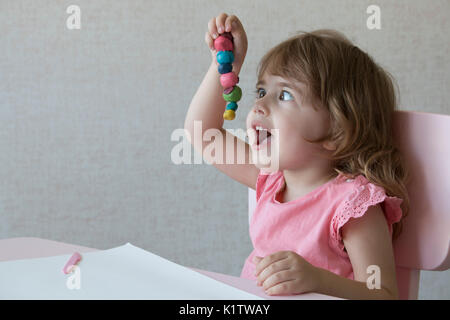 Petite fille jouer avec la pâte à modeler à la maison Banque D'Images