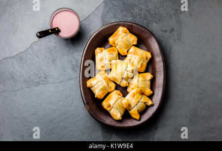 Mini empanadas chiliennes sur plaque d'argile avec boisson typiquement chiliens vino con harina - vin rouge avec de la farine grillée. Banque D'Images