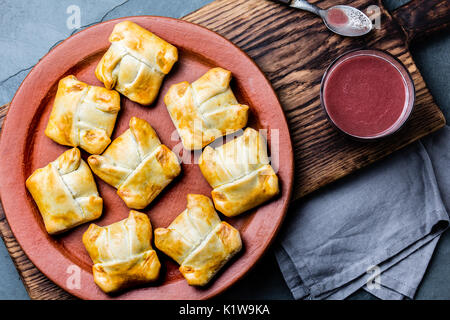 Mini empanadas chiliennes sur plaque d'argile avec boisson typiquement chiliens vino con harina - vin rouge avec de la farine grillée. Banque D'Images