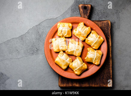 Mini empanadas chiliennes sur plaque d'argile avec boisson typiquement chiliens vino con harina - vin rouge avec de la farine grillée. Banque D'Images