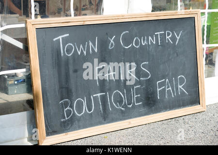 Un tableau noir avec un message écrit à la main sur elle à la craie la publicité d'une Town & Country Fair à Arundel, West Sussex, Angleterre. Banque D'Images