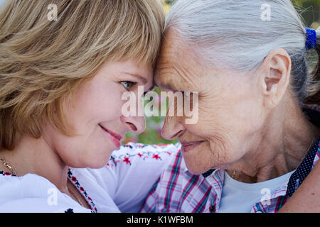 Middle-aged woman hugging sa mère dans la nature. L'émotion réelle Banque D'Images