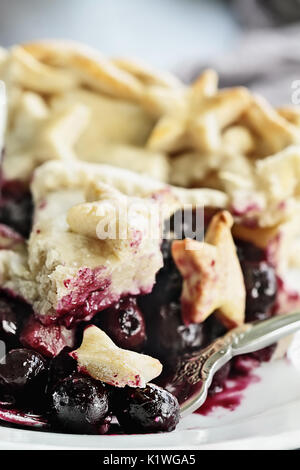 Résumé Vue d'une tranche de tarte aux bleuets avec treillis et stars de la croûte terrestre. L'extrême profondeur de champ avec selective focus on bouchée de nourriture sur la fourchette. Banque D'Images