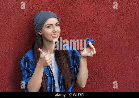 Hipster girl Playing with fidget spinner. Portrait de jeune femme avec spinner rotatif. La mode populaire, le Toy Banque D'Images