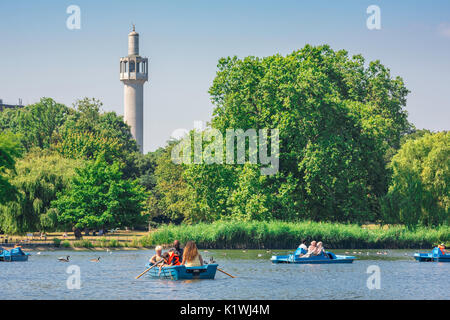 Regent's Park de Londres, la vue sur le lac de plaisance et les touristes appréciant un après-midi d'été avec le minaret de la mosquée centrale à l'arrière, au Royaume-Uni. Banque D'Images