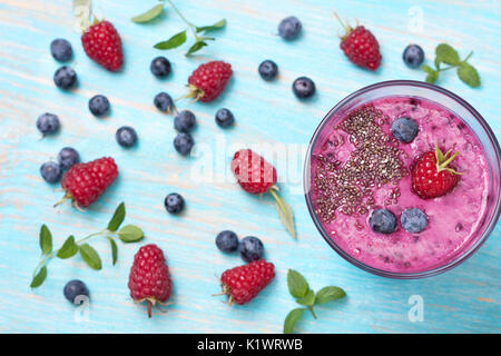 Des smoothies avec des bleuets et framboises, chia graines dans une tasse en verre. Vue de dessus Banque D'Images