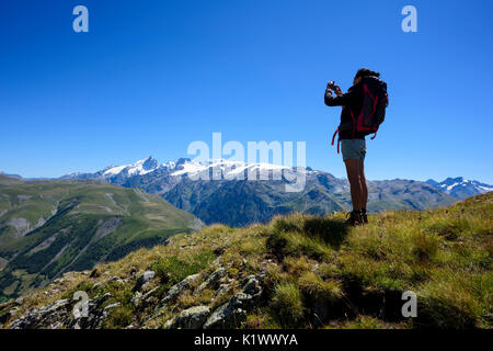 La prise de photo de femme randonneur un paysage de montagne avec son smartphone dans les Alpes avec Glacier La Meije, Isère, France Banque D'Images