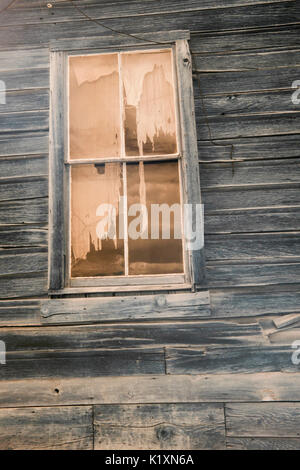 Close up de rideaux en lambeaux de fenêtre ancienne maison en bois en sépia. Banque D'Images