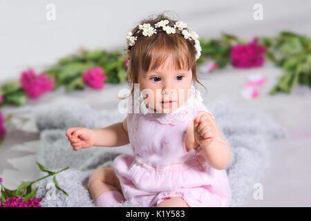 Un petit enfant heureux de race blanche fleur, fond gris Banque D'Images