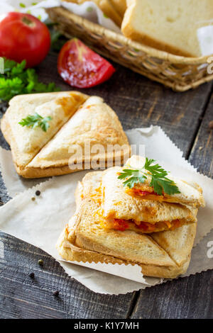 Enfoncée et double toasted sandwich avec du poulet, des carottes, de la Corée et les tomates, fromage servi sur un sandwich sur une table en bois de cuisine. Banque D'Images