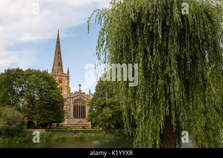 L'église Holy Trinity à Stratford upon Avon, vue de l'autre côté de la rivière Avon avec une petite willow tree. Banque D'Images