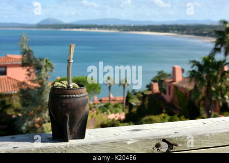 Caféine-Uruguay Traditionnel Chaud boisson riche mate (Yerba Mate) dans une calebasse calebasse avec la vue à couper le souffle des baleines péninsule (Punta Ballena) clo Banque D'Images