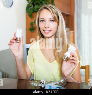 Smiling blond woman holding ampoules à la maison Banque D'Images