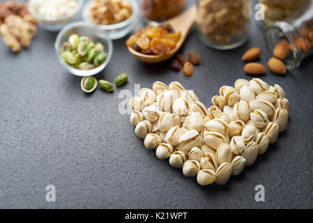 Les pistaches formant une forme de coeur sur fond d'ardoise Banque D'Images
