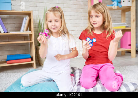 Les petites filles jouant avec Fidget Spinner Banque D'Images