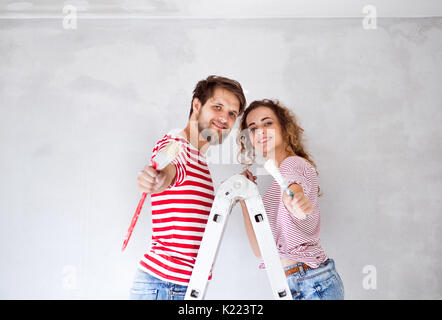 Couple Jeune peinture des murs dans leur nouvelle maison. Banque D'Images