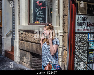 Tourist posant pour photographier en face de Beatles Shop dans Mathew Street, Liverpool, England, UK Banque D'Images