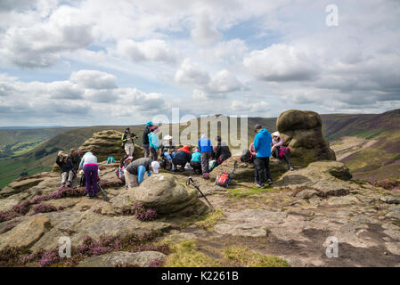 Groupe de touristes étrangers profitant du paysage de Peak District à Roger Sonnerie sur Kinder Scout, Edale, Derbyshire. Banque D'Images