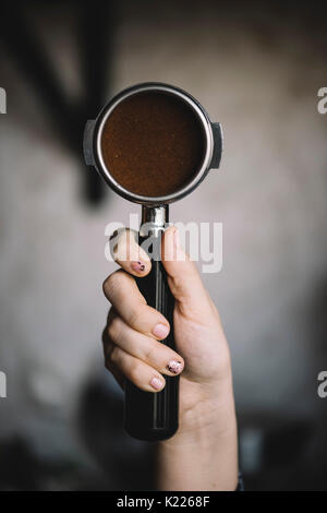 Human hand holding un portafilter avec le café du matin du Banque D'Images