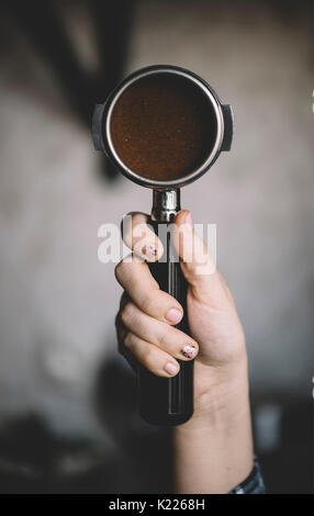 Human hand holding un portafilter avec le café du matin du Banque D'Images