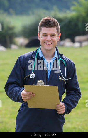 Portrait of VET in Field avec des moutons en arrière-plan Banque D'Images