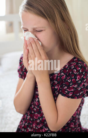 Fille de souffrir avec l'éternuement froid dans les tissus Banque D'Images