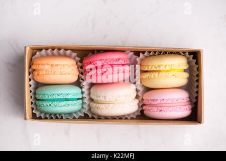 Macarons sucrés. Les cookies français différents macarons dans une boîte de papier. Banque D'Images