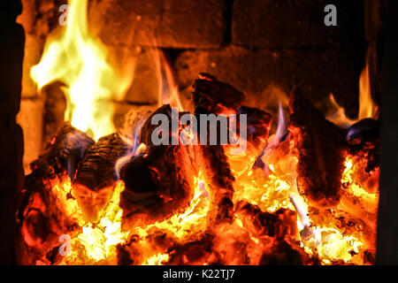 Feu de brûler à l'intérieur d'un poêle en brique - bois, frêne, de flammes. Banque D'Images