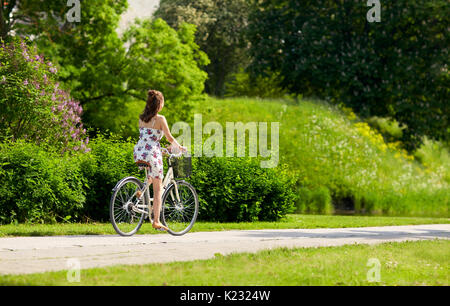 Happy woman riding bicycle fixie en parc d'été Banque D'Images