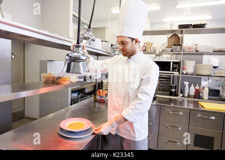 Heureux homme, la cuisson à chef de cuisine restaurant Banque D'Images