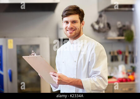 Chef avec presse-papiers faisant l'inventaire à restaurant Banque D'Images