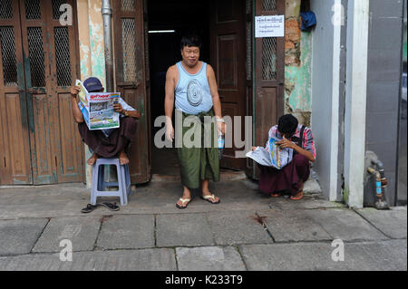 01.10.2013, Yangon, République de l'Union du Myanmar, en Asie - Deux hommes sont vus lire un journal sur le trottoir à Yangon. Banque D'Images