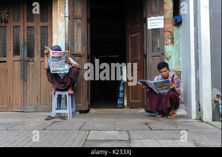 01.10.2013, Yangon, République de l'Union du Myanmar, en Asie - Deux hommes sont vus lire un journal sur le trottoir à Yangon. Banque D'Images