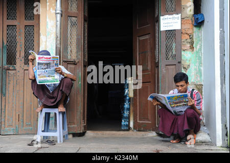 01.10.2013, Yangon, République de l'Union du Myanmar, en Asie - Deux hommes sont vus lire un journal sur le trottoir à Yangon. Banque D'Images