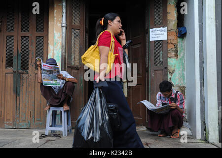 01.10.2013, Yangon, République de l'Union du Myanmar, en Asie - Deux hommes sont vus lire un journal sur le trottoir à Yangon. Banque D'Images