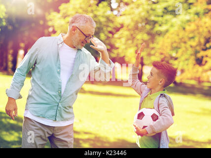Vieil homme et garçon avec ballon de soccer en haut cinq Banque D'Images