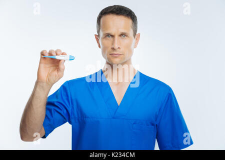 Mature doctor posing avec thermomètre corps Banque D'Images
