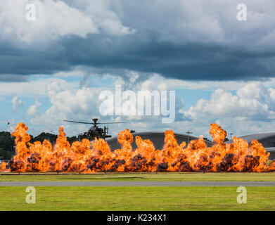 L'hélicoptère Apache donnant une démonstration de vol au Farnborough 2016 avec l'ajout de pièces pyrotechniques à l'excitation et de montrer son agilité Banque D'Images