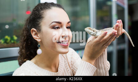 Portrait of young smiling woman holding un lézard dans les mains Banque D'Images