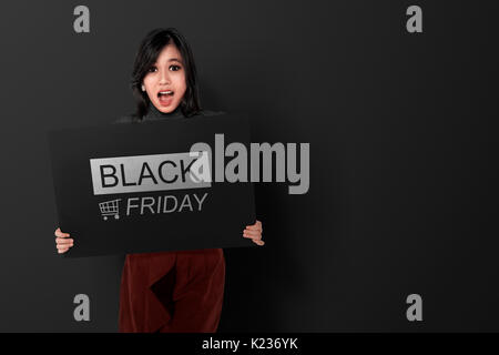 Heureux asian woman holding banner avec le Black Friday sur fond noir Banque D'Images