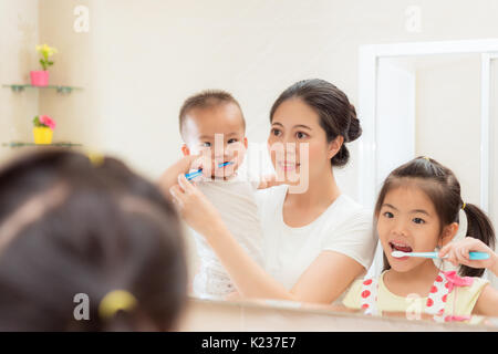 La vie quotidienne de la famille bonheur photo de jeune mère avec enfant regardant à l'aide de miroir pour le nettoyage des dents brosse à dents dans la salle de bains ensemble chaque matin et de ni Banque D'Images