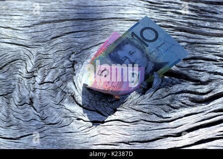 Close up of Australian argent sur bois. Note de cinq dollars et dix dollar note. Dollars en plein air dans un parc. Banque D'Images