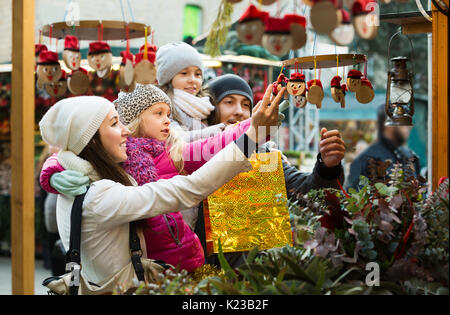 Famille avec enfants l'achat de jouets traditionnels Tio Caga à la juste. L'accent sur fille blonde Banque D'Images