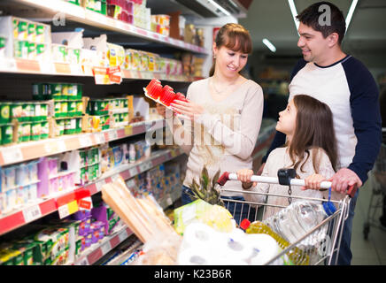 Couple Famille avec fille en choisissant le yogourt aux fruits et au lait au supermarché. Se concentrer sur la fille Banque D'Images