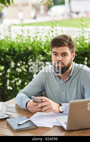 Pensive Businessman Working in Cafe en plein air Banque D'Images