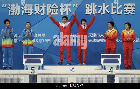 (170828) -- Tianjin, le 28 août 2017 (Xinhua) -- or olympique Shi Tingmao (3e R) de Chongqing, Wang Han, médaillé d'argent (2e L) de Hebei et médaillé de bronze, Wu Chunting (R) de Guangdong posent avec leurs entraîneurs au cours de la cérémonie après le tremplin 3m femmes finale de plongée sous-marine à la 13e Jeux nationaux chinois en Chine du nord, la municipalité de Tianjin, le 28 août 2017. (Xinhua/Ding Xu) Banque D'Images