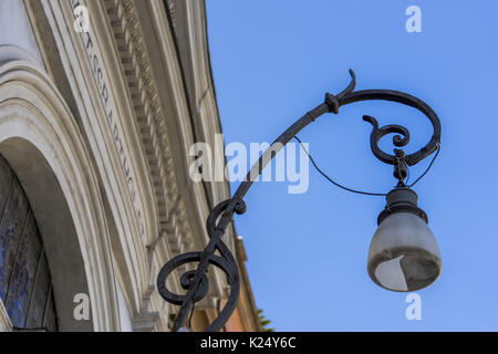 Belle rue lanterne en fer forgé et d'un abat-jour en verre sur la façade d'un bâtiment ancien. Rome, Italie Banque D'Images