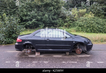 Avec les roues de voiture volé levé sur briques dans street in UK Banque D'Images