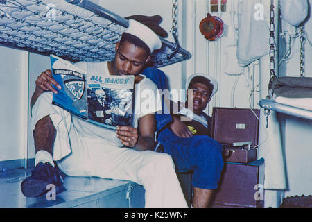 Deux marins américains noirs se détendre dans leurs quartiers. Une seule lecture, une copie de "toutes mains" magazine qui sur près semble être datée de mai 1946 Banque D'Images