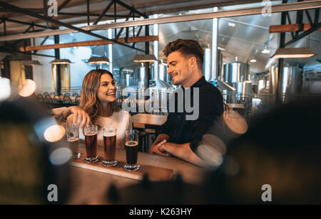 Jeune homme et femme au bar avec différents types de bières. Bar Brasserie à couple et dégustation de bières. Banque D'Images